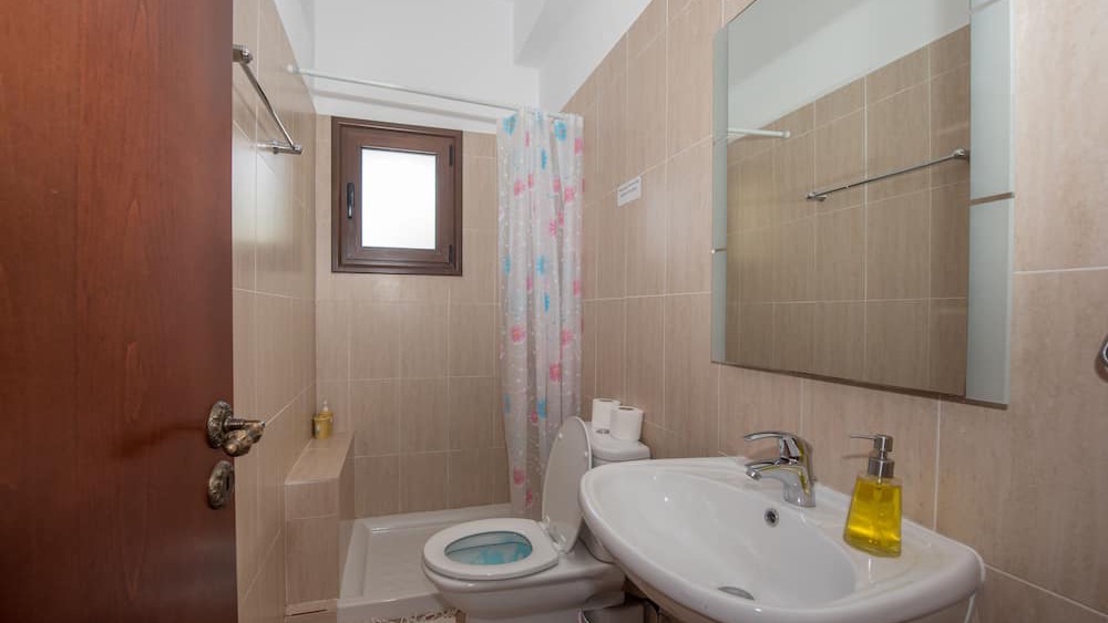 A clean, simple shower room with basin and mirror