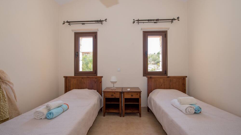A twin bedroom with two beds and garden views