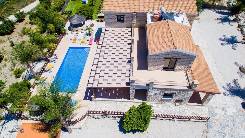 Aerial view of the villa, pool, shaded pergola and surrounding garden