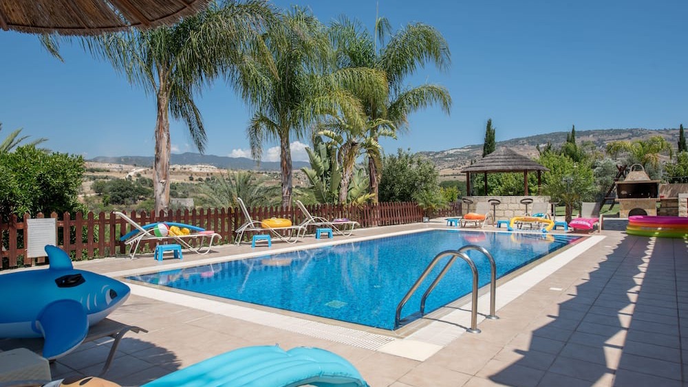Sun loungers beside the pool with mountains in the distance