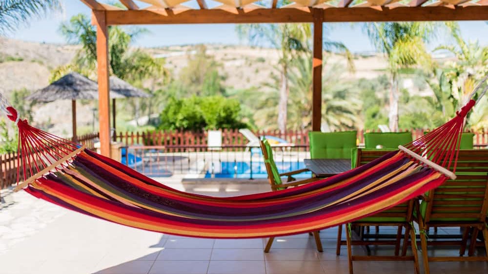 A striped hammock under the pergola overlooking the pool